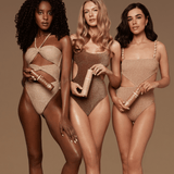 Three women wearing beige swimsuits against a brown background